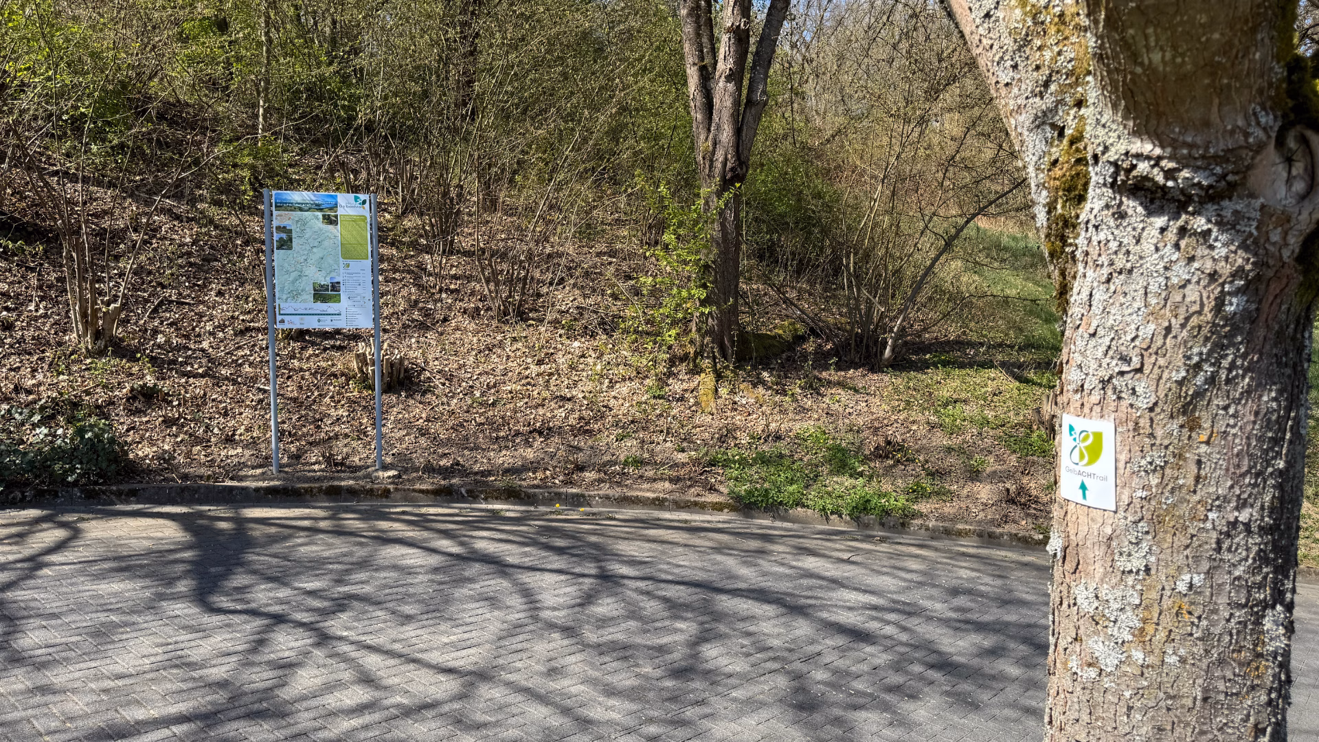 Wanderparkplatz am Startpunkt des GelbACHTrails bei Montabaur mit Übersichtstafel zur Route und Wegemarkierung am Baum.